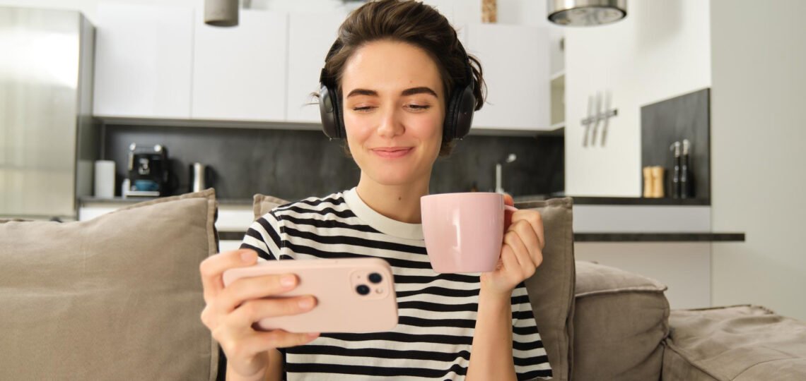 Woman watching her phone. Like her, you can watch the best Youtube channel to improve your French.