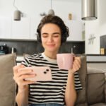 Woman watching her phone. Like her, you can watch the best Youtube channel to improve your French.