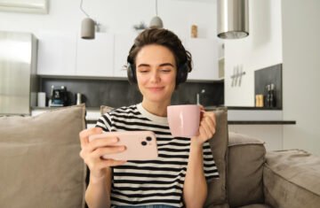 Woman watching her phone. Like her, you can watch the best Youtube channel to improve your French.