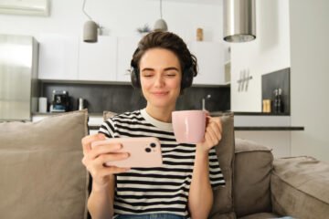 Woman watching her phone. Like her, you can watch the best Youtube channel to improve your French.